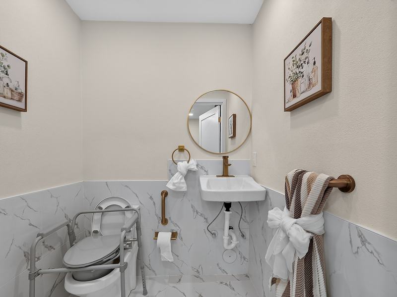 A bathroom with grab bars, a roll-in shower, and a shower wheelchair