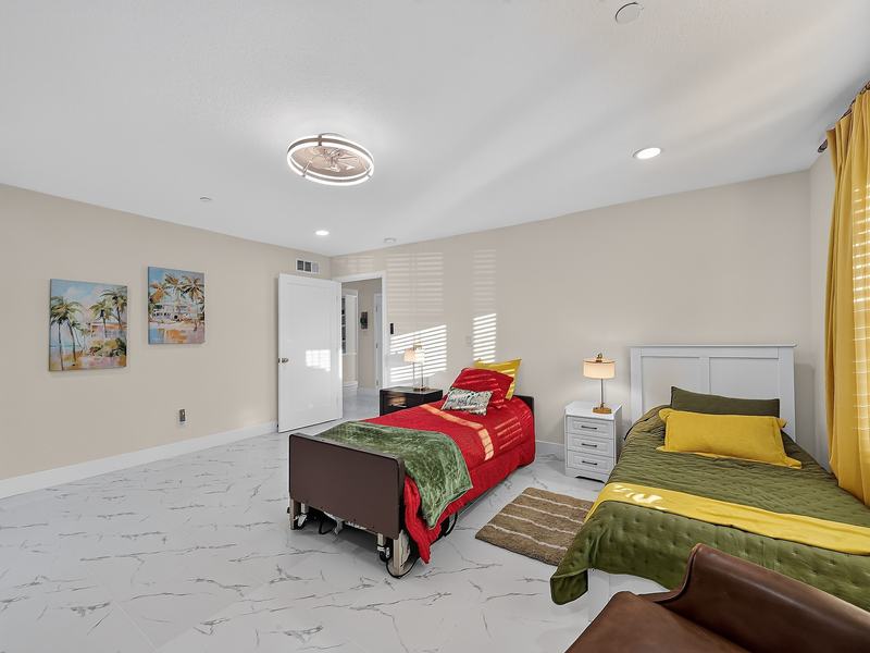 A resident bedroom with an adjustable hospital-style bed and an electric fireplace