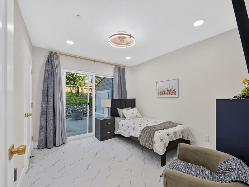 A resident bedroom with a twin bed and its own sliding door to the backyard