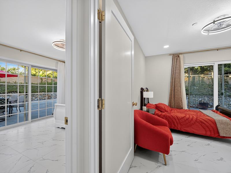 A bedroom doorway looking through to the patio, with the bed beside its own garden door