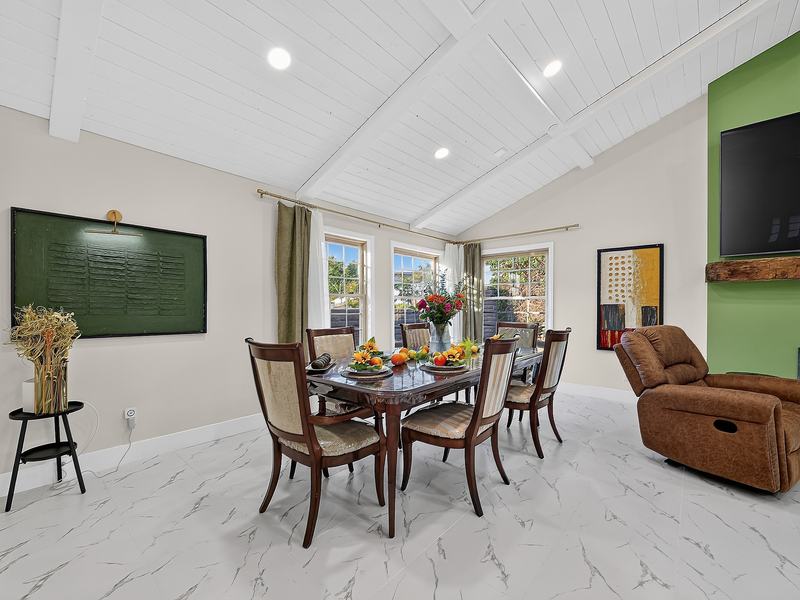 The dining area with the table set, a green chalkboard on the wall, and daylight from the garden windows