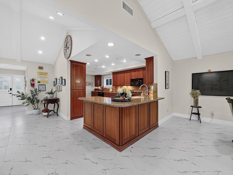 The dining table set for six beneath the vaulted wood ceiling