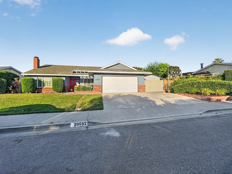 The front of Peaceful Haven from across Los Osos Drive — a single-story house with a wide lawn and driveway