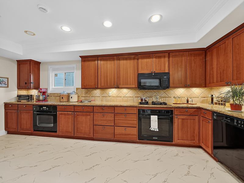 The kitchen: wood cabinets, granite counters, and a gas range